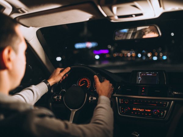young-man-driving-his-car-night-time